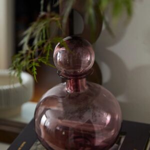 A glass vase sitting on top of a book.