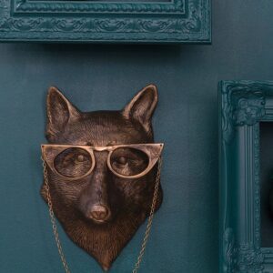 A dog head with glasses hanging on the wall.
