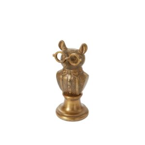 A gold owl statue with glasses on top of it.