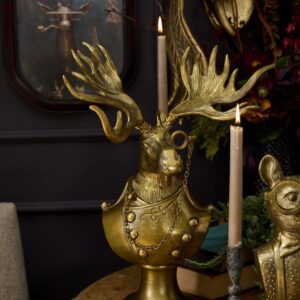 A gold statue of a deer head with antlers.