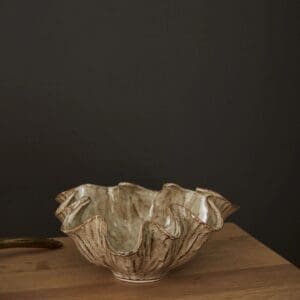 A bowl with gold leaf on top of a wooden table.