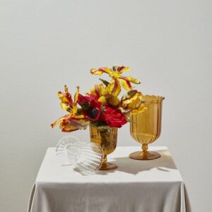 A table with two vases and a white cloth.