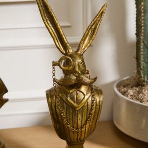 A gold statue of a rabbit with chains on its head.