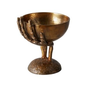 A bronze chalice held by a skeletal hand sculpture.
