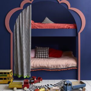 Children's bunk bed with curtains and toys scattered nearby.