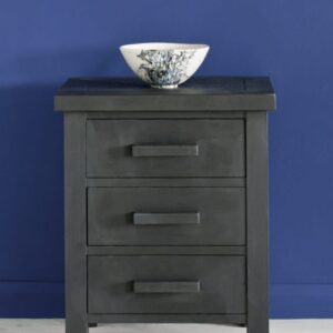 Black three-drawer nightstand with a decorative bowl on top against a blue wall.